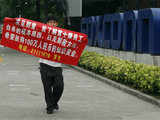 A man carries a banner outside a Foxconn factory