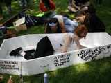 A woman prepares a prop coffin before a feminist rally