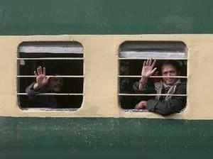 Karachi : Indian fishermen wave to journalists from a train as they leave for t...