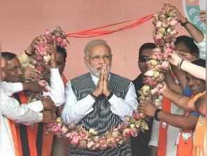 Sanand : Prime Minister Narendra Modi being presented a lotus-garland by the BJP...