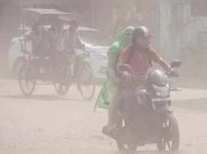 New Delhi: A motorist makes his way through a mild dust storm at Azad Market in ...