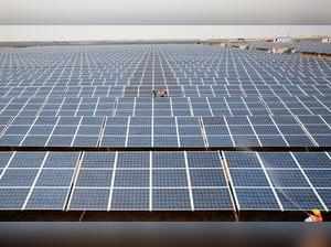 FILE PHOTO: Workers install photovoltaic solar panels at the Gujarat solar park under construction in Charanka village