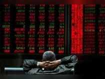 Beijing: An investor looks at stock market prices on a display at a brokerage in...