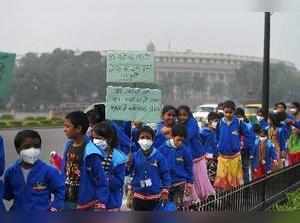 New Delhi: Children wearing air pollution masks attend a demonstration to sprea...