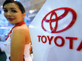 Model stands next to Toyota's logo