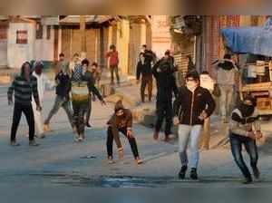 Srinagar: Youth throw stones at the police during a clash in Srinagar on Wednesd...