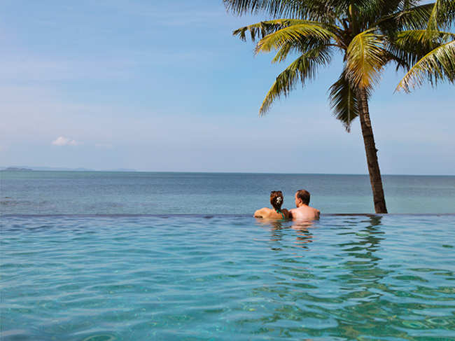 travel-couple-honeymoon-pool-sea-ThinkstockPhotos-545118228