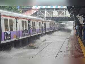 Mumbai: A train chugs at water-logged tracks during heavy rains in Mumbai on Sat...