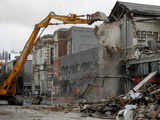 Demolition workers tear down damaged building