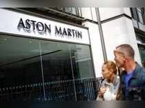 People walk past an Aston Martin dealership in central London