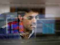 A broker reacts while trading at his computer terminal at a stock brokerage firm in Mumbai