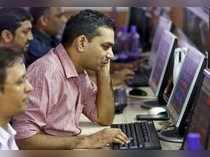 Brokers trade at computer terminals at stock brokerage firm in Mumbai