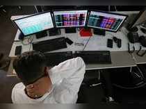 A broker reacts while trading at his computer terminal at a stock brokerage firm in Mumbai