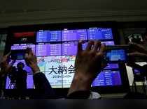 Attendees take pictures of a stock quotation board after a ceremony marking the end of trading in 2018 at the Tokyo Stock Exchange (TSE) in Tokyo