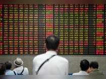 People look at an electronic board showing stock information at a brokerage house in Shanghai.