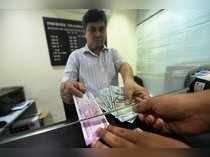 New Delhi: A customer exchanges currency at a forex bureau after the Rupee hit a...