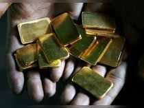 FILE PHOTO: A worker shows gold biscuits at a precious metals refinery in Mumbai
