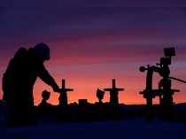 FILE PHOTO: Worker checks valve of oil pipe at oil field owned by Bashneft company near Nikolo-Berezovka