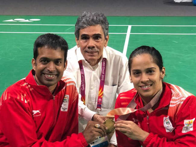 Saina Nehwal (R) with coach Pullela Gopichand (L) and father Harvir Singh Nehwal (C) after willing a gold in 2018 Commonwealth Games.