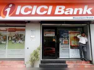 A man speaks on the phone outside an ICICI Bank branch in Kolkata