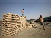 Labourers stand after unloading cement bags from a freight train at Ghaziabad railway station