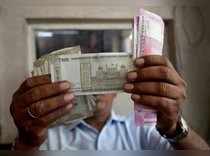 A cashier checks Indian rupee notes inside a room at a fuel station in Ahmedabad