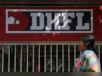 A woman walks past a signboard of Dewan Housing Finance Corporation Ltd. (DHFL) outside its office on the outskirts of Mumbai