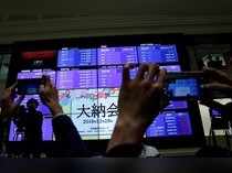 FILE PHOTO: Attendees take pictures of a stock quotation board after a ceremony marking the end of trading in 2018 at the Tokyo Stock Exchange (TSE) in Tokyo