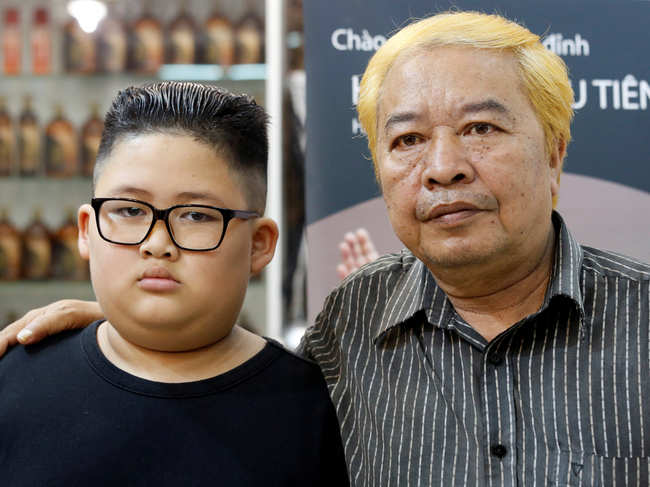 To Gia Huy, 9, and Le Phuc Hai, 66, pose after having their haircut in North Korean leader Kim Jong Un and U.S. President Donald Trump styles in a haircut salon in Hano​i.