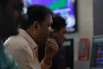 A broker reacts while trading at his computer terminal at a stock brokerage firm in Mumbai