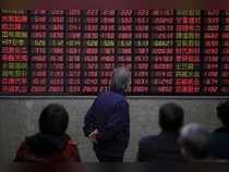 Investors look at an electronic board showing stock information at a brokerage house in Shanghai