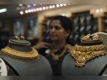 A woman tries on a gold necklace inside a jewellery shop in Hyderabad