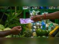 Kolkata: A customer uses a 2000 rupee note to pay a vegetable vendor, in Kolkata...