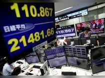 Employees of a foreign exchange trading company work next to monitors displaying Japan's Nikkei stock average and the Japanese yen's exchange rate against the U.S. dollar as a television screen broadcasting second North Korea-U.S. summit in Tokyo