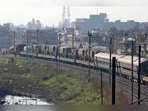 Indian army trucks are transported on a train near a railway station on the outskirts of Jammu