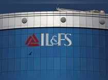FILE PHOTO: A bird flies next to the logo of IL&FS installed on the facade of a building at its headquarters in Mumbai