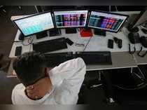 A broker reacts while trading at his computer terminal at a stock brokerage firm in Mumbai