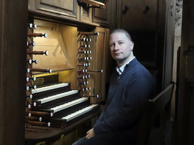 Johann Vexo, the organist who was playing at evening mass inside Notre Dame when flames began licking at the iconic cathedral's roof, poses at the pipe organ at Notre Dame de Nancy cathedral, eastern France.