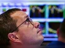 Trader looks at stock prices on a screen while working on the floor of the NYSE
