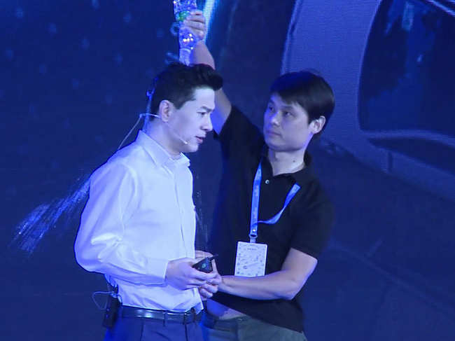 ​​Robin Li (L) calmly resumed his presentation to applause after the stranger doused water over Baidu CEO's head.​