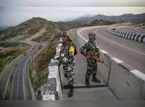 Jammu: Security personnel stand guard on Jammu-Srinagar National Highway as the ...