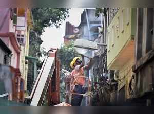 Kolkata: Metro workers dismantle the loose parts of damaged buildings after evac...