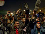 Egyptian anti-government demonstrators wave their shoes