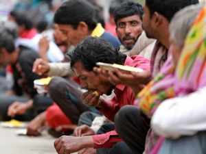 Homeless people eat a meal distributed by the Delhi government. (AP Photo)