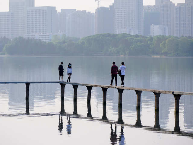 People walk along a lake