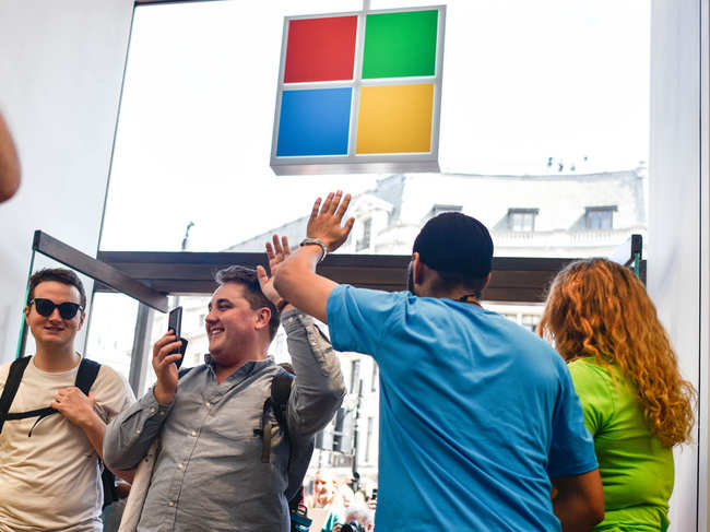 File photo of July 2019: Microsoft employees high five shoppers during the Microsoft store's opening in London, England. Microsoft opened their first flagship store in Europe this morning, August 11.