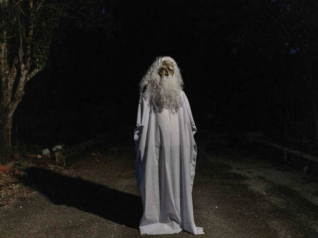 This picture taken on April 16, 2020 shows Urabil Alias, 38, wearing a ghost costume as he walks in a residential area to scare people from leaving their houses during the Movement Control Order, limiting the activities of people in Malaysia as a preventive measure against the spread of the COVID-19 novel coronavirus, in Kemaman, a district in Terengganu state. A ghostly figure with wild hair and a flowing beard is haunting a small Malaysian community in a bid to ensure superstitious residents stay inside during the country's coronavirus lockdown.