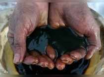 FILE PHOTO: An employee holds a sample of crude oil at the Irkutsk Oil Co-owned Yarakta field in the Irkutsk region