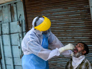 A health worker wearing protective gear checks a resident AFP