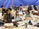 Evacuees sit through an earthquake at a temporary shelter